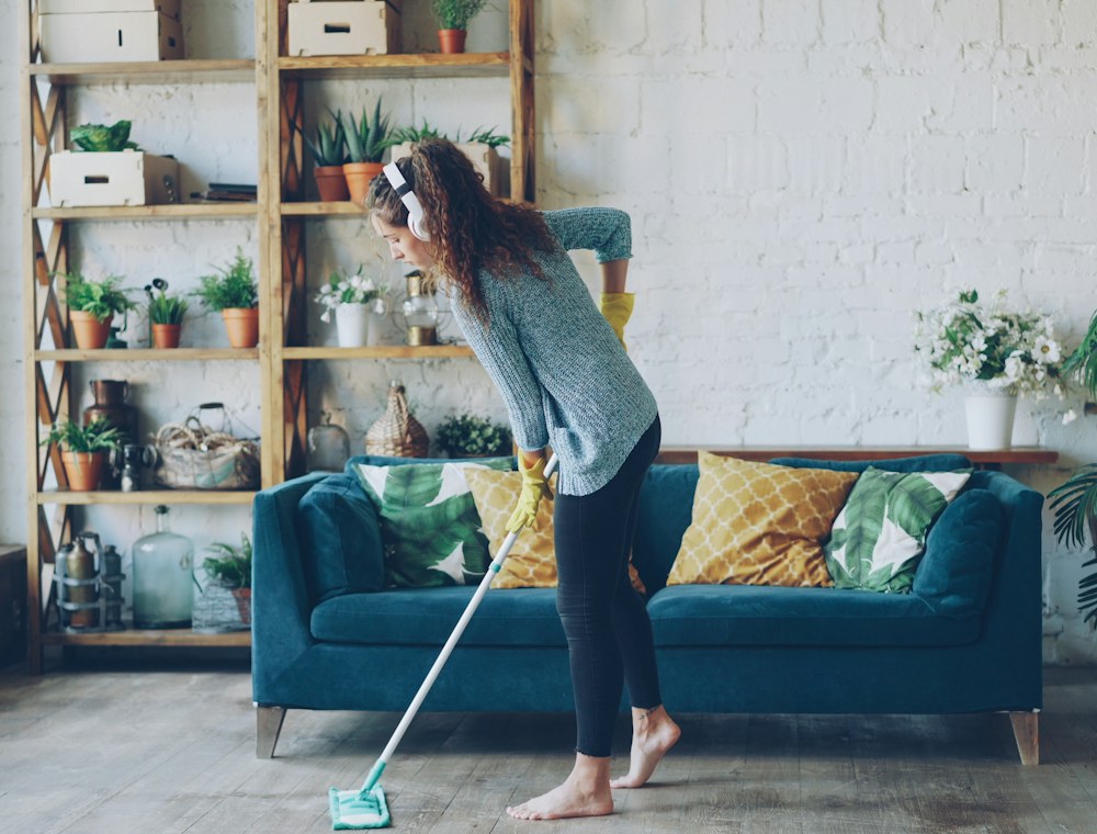 A cleaner mopping a bright living room