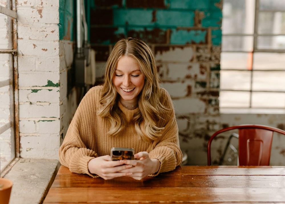 A woman reading something on her phone at a cafe table